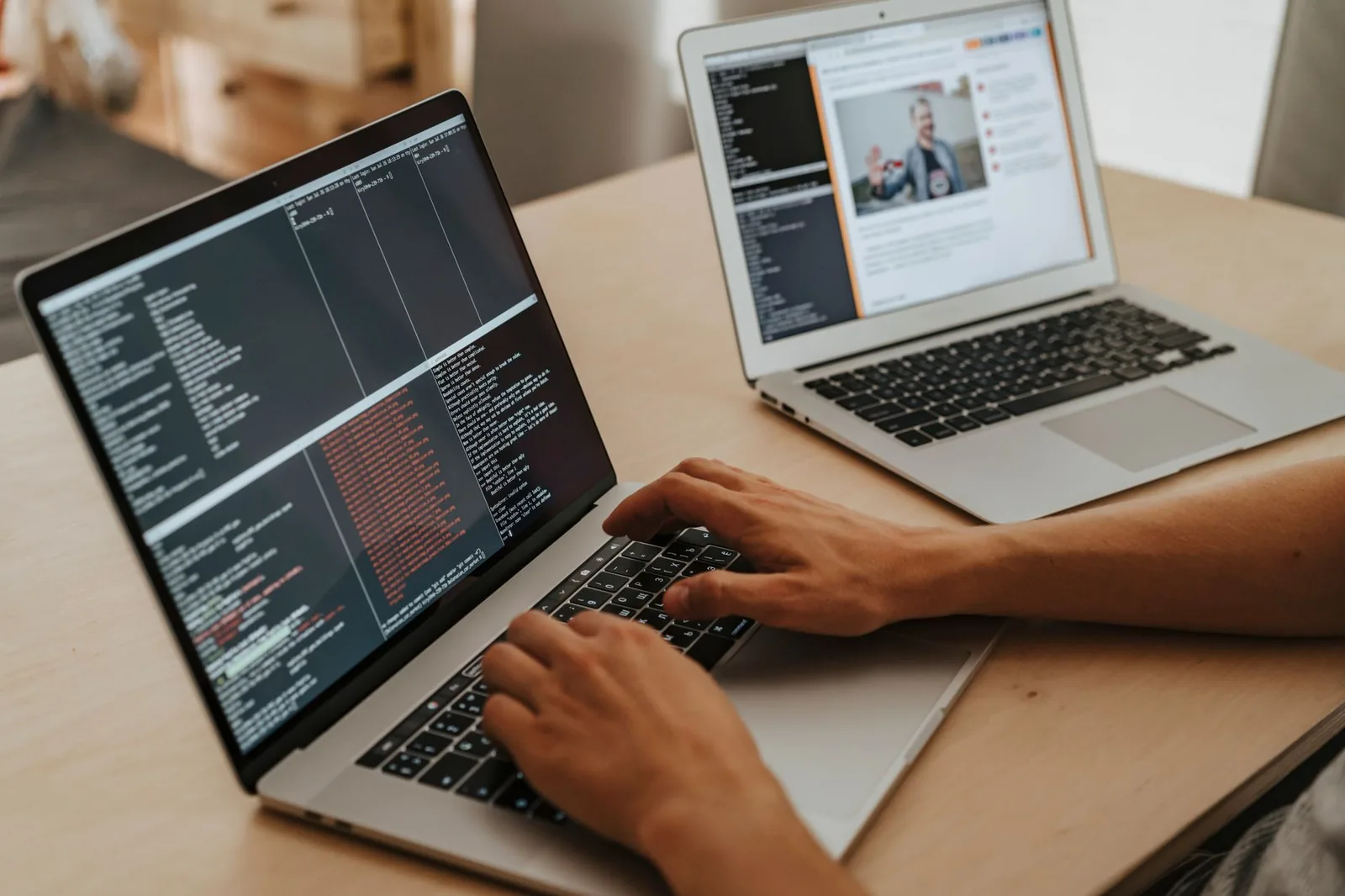 Developer working on custom bespoke software on laptop with code terminal and dashboards visible