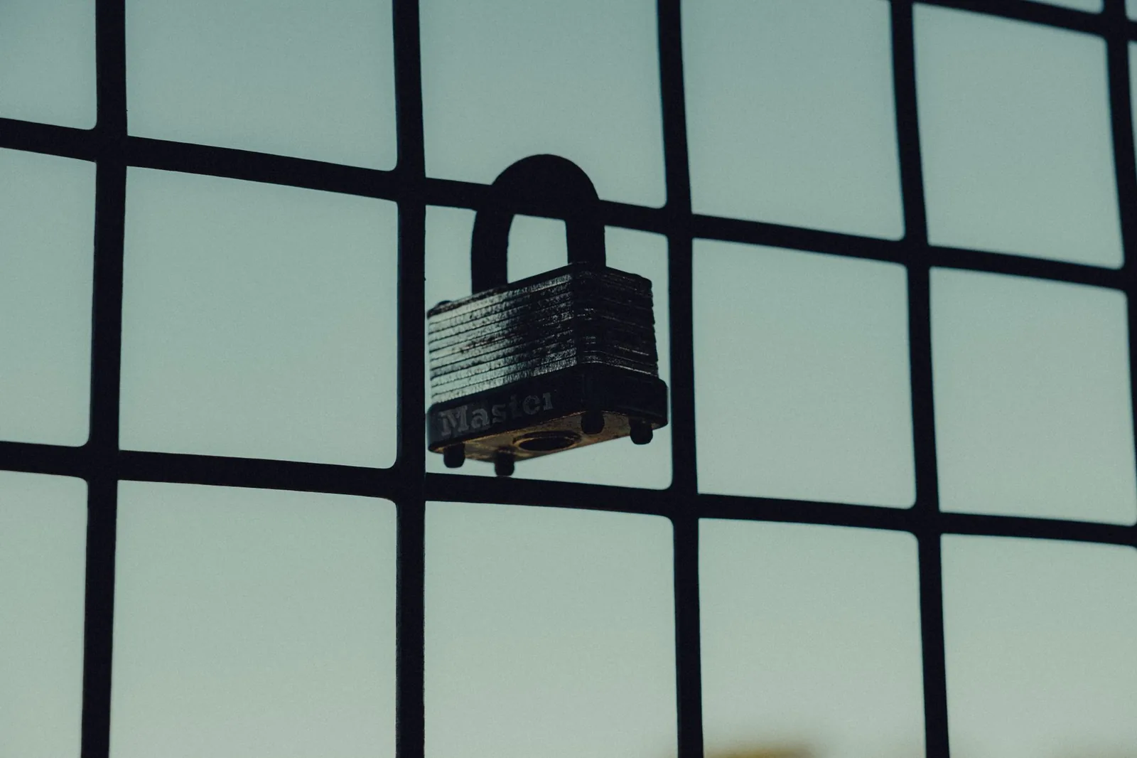 Padlock resting on a keyboard beside server hardware, representing least-privilege security for AI agent database access