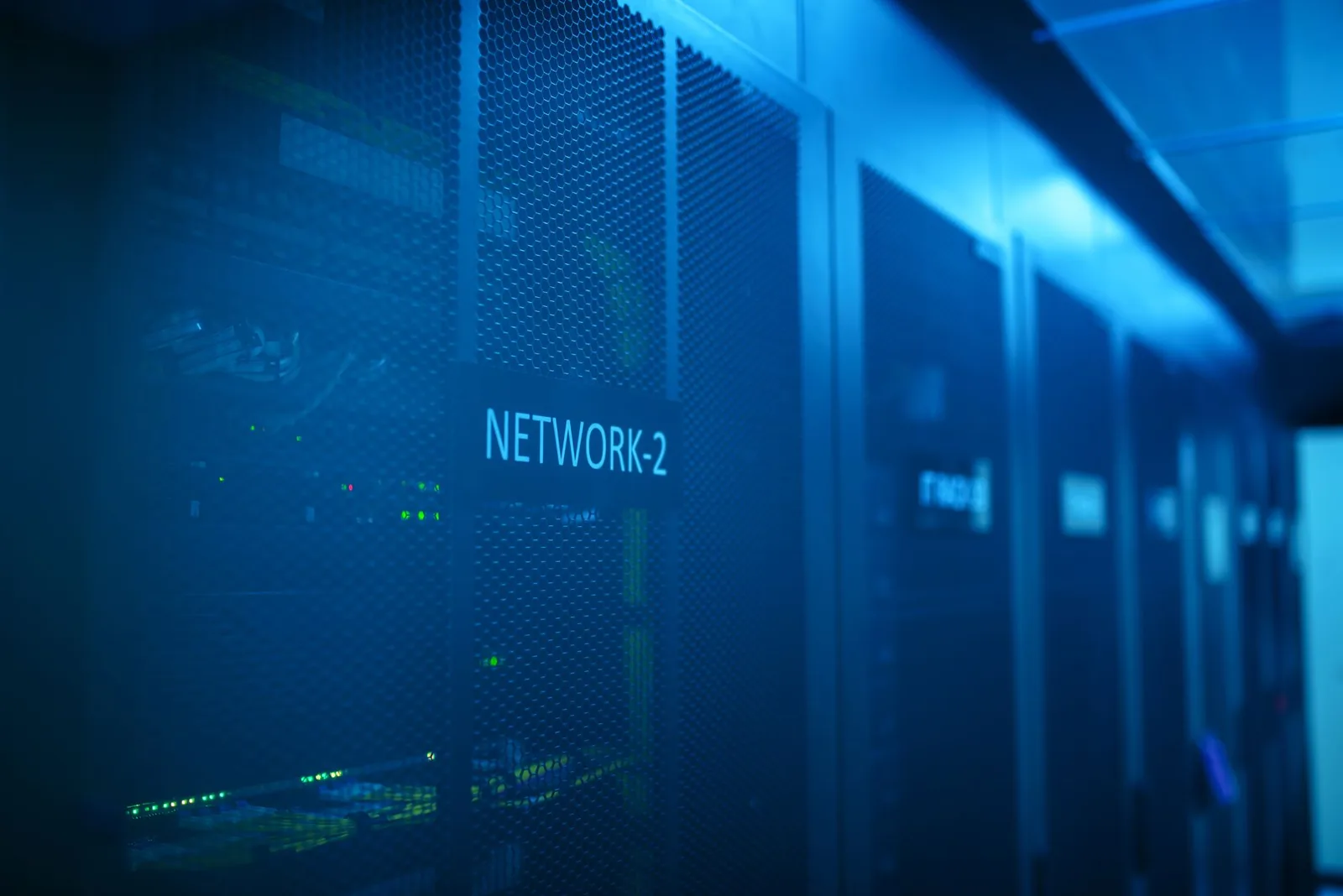 Rows of server racks with glowing indicator lights in a data center, illustrating database-level access control for AI agents