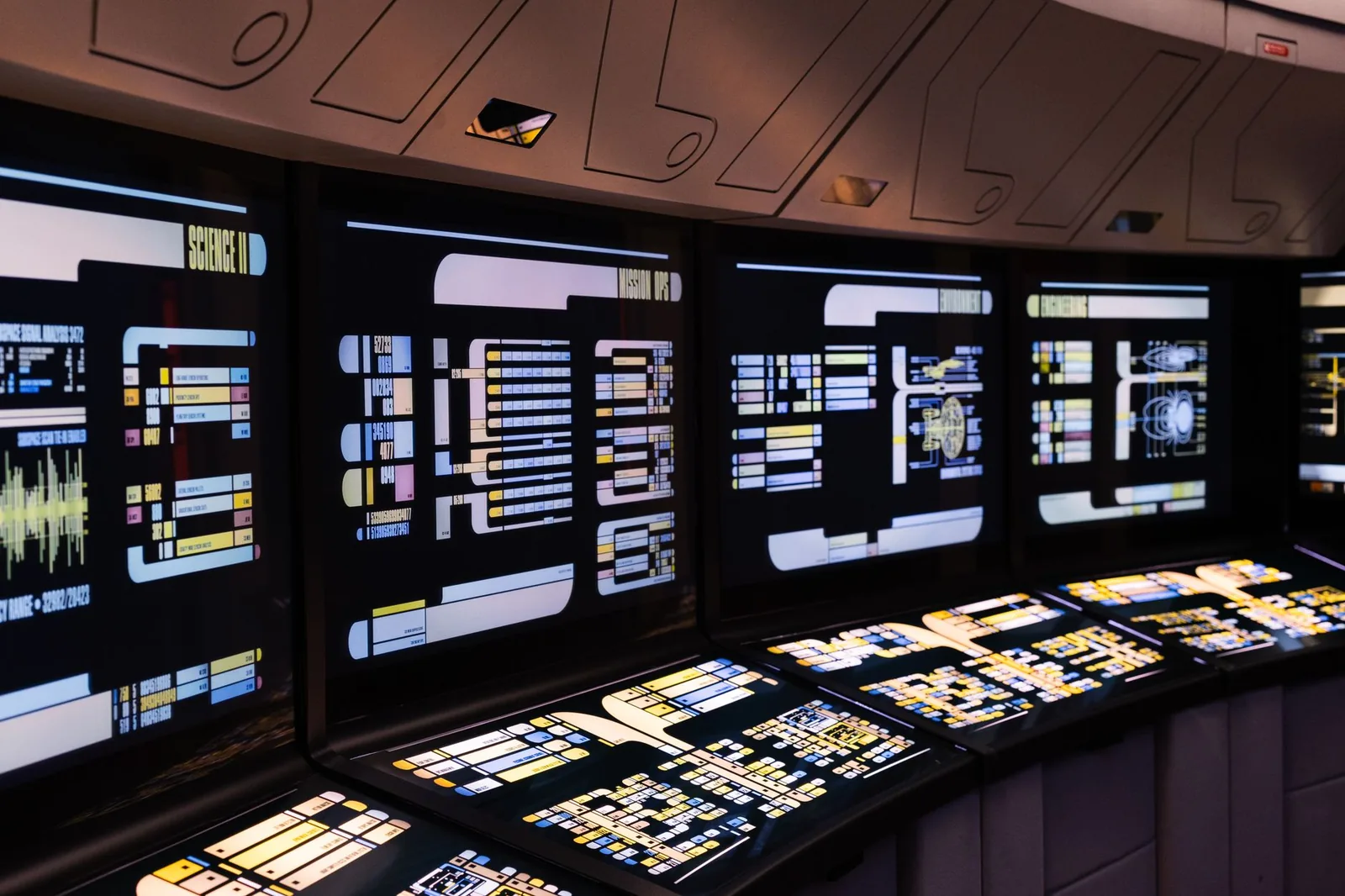 Developer reviewing observability dashboards with traces and cost metrics for an AI agent on multiple monitors