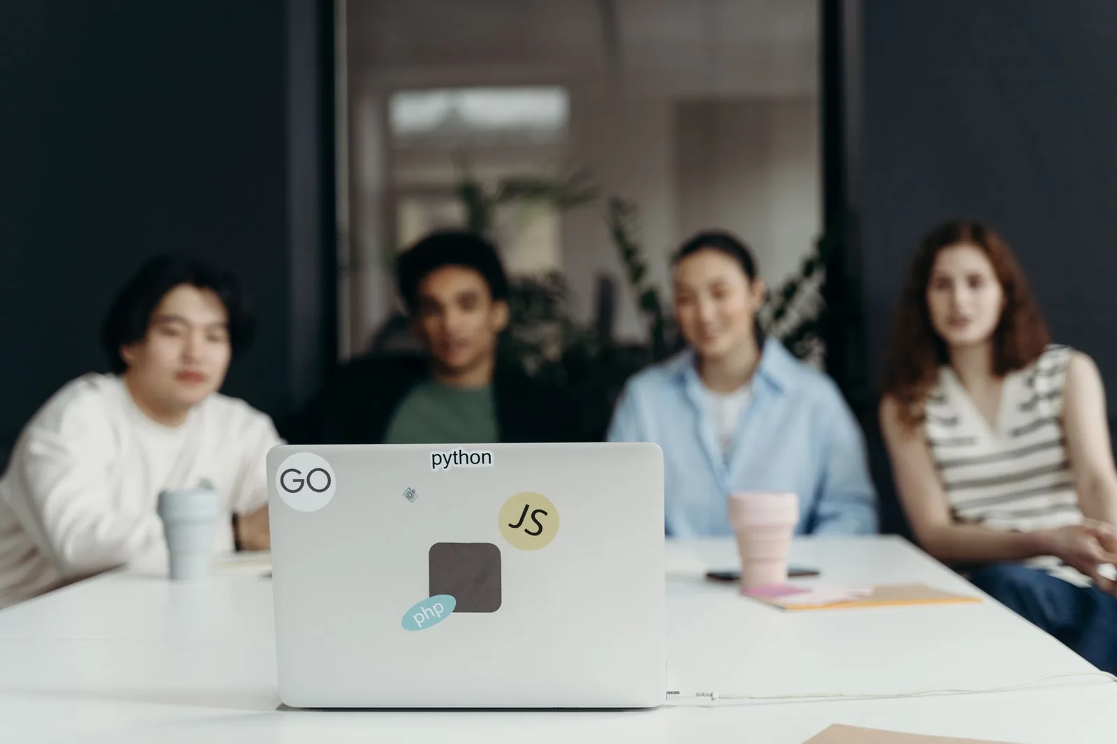 Team reviewing a software outsourcing proposal on a laptop with printed contracts on the desk