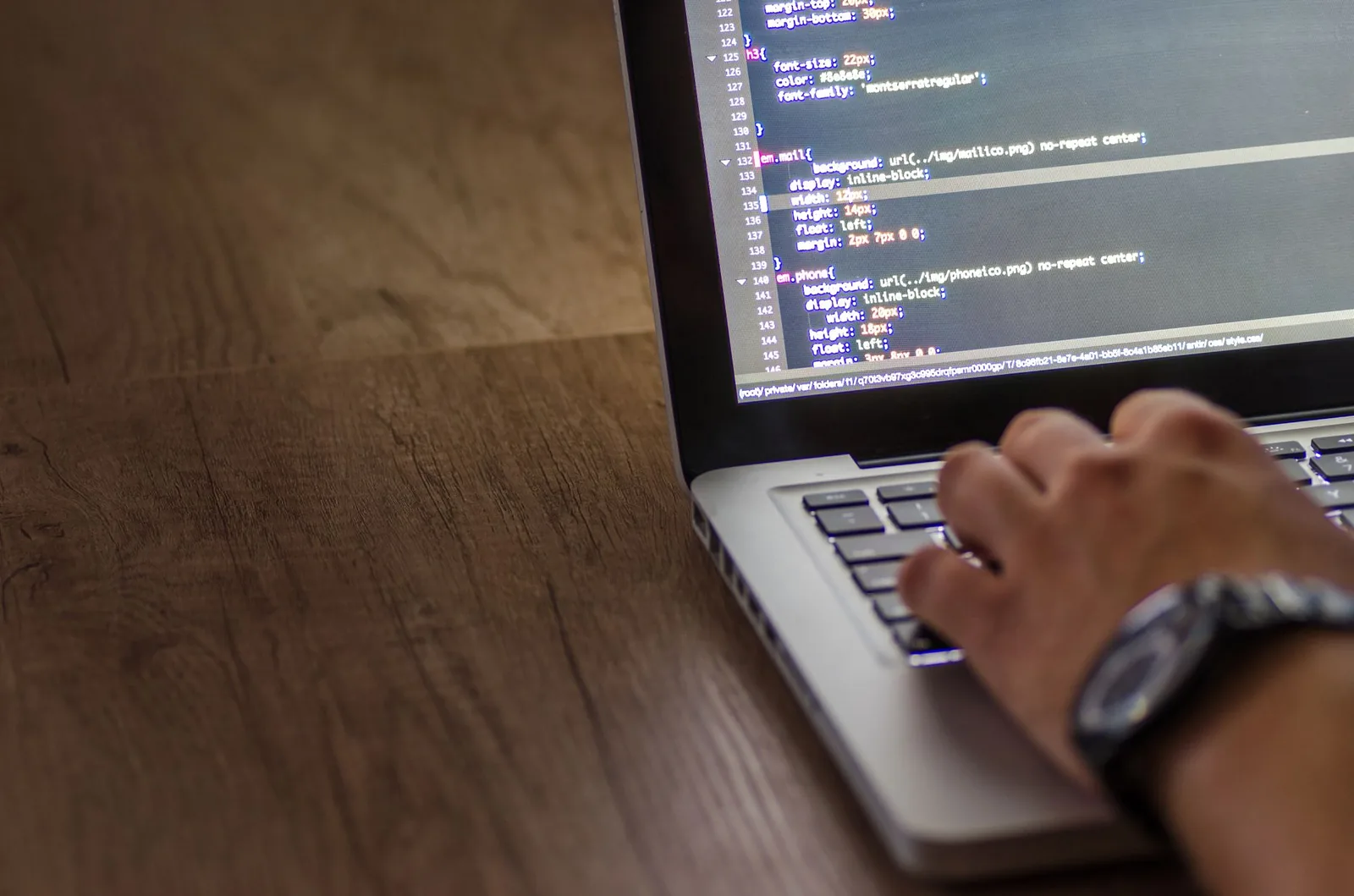 Software developer working on custom application code and architecture diagrams on a laptop screen