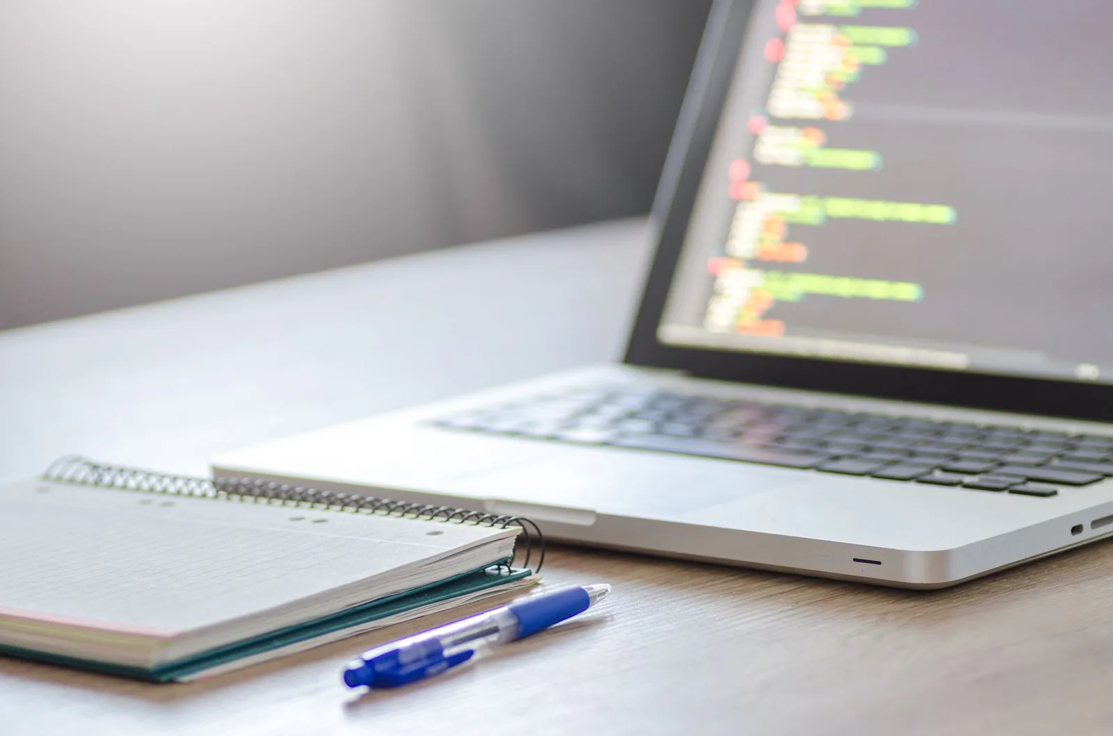 Developer comparing software options on laptop with spreadsheet showing build versus buy cost analysis