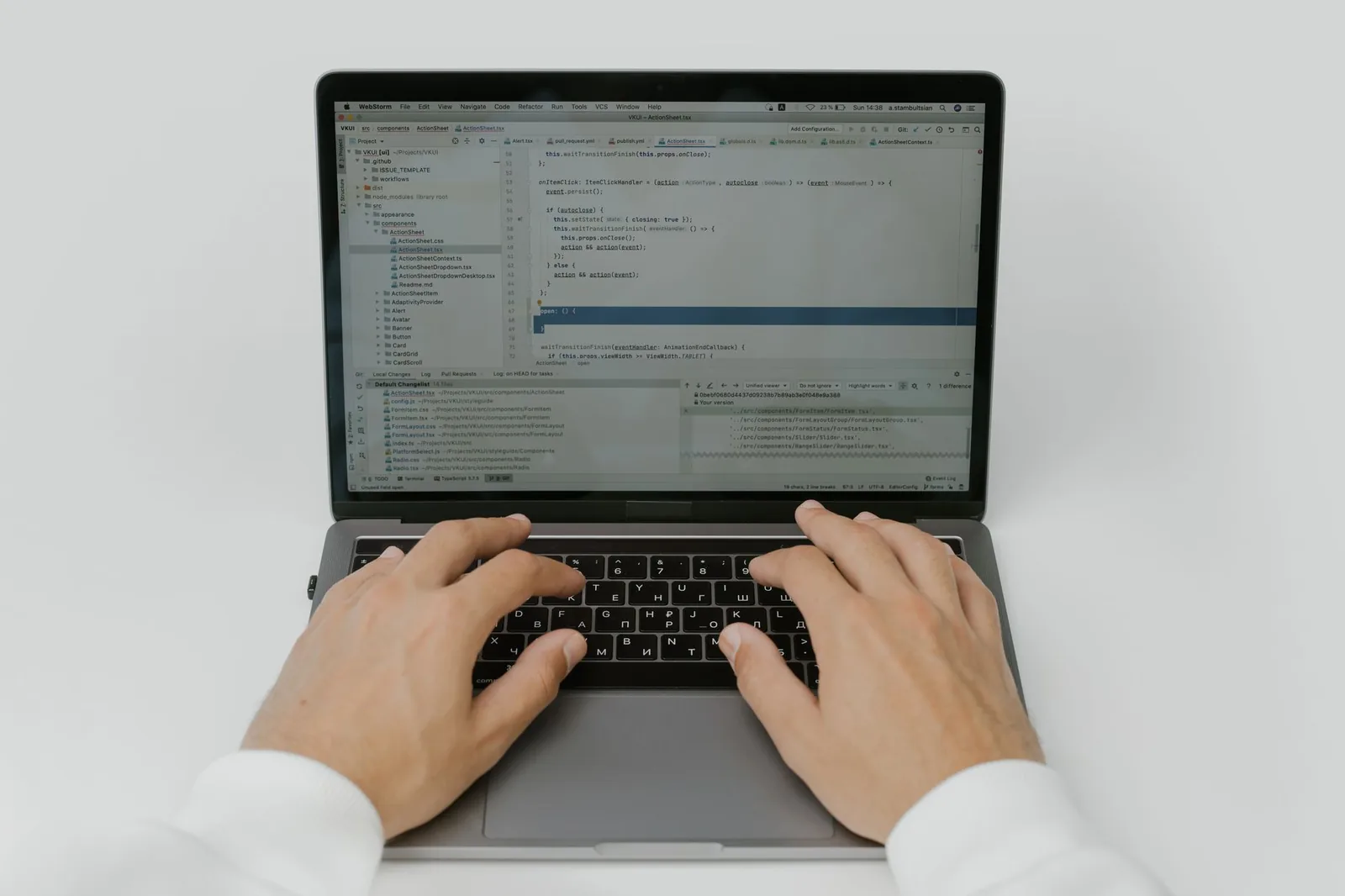 Software developer building a custom business application on dual monitors with code editor