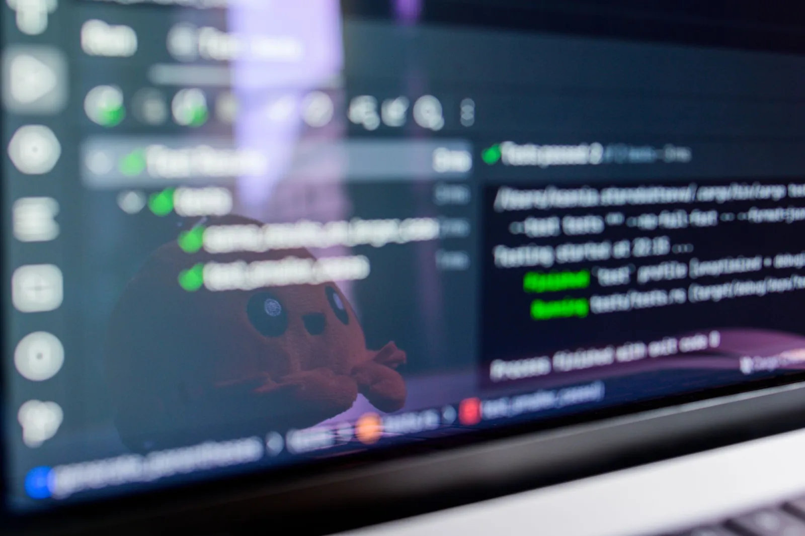 Developer reviewing code and agent test results on a laptop screen at a desk