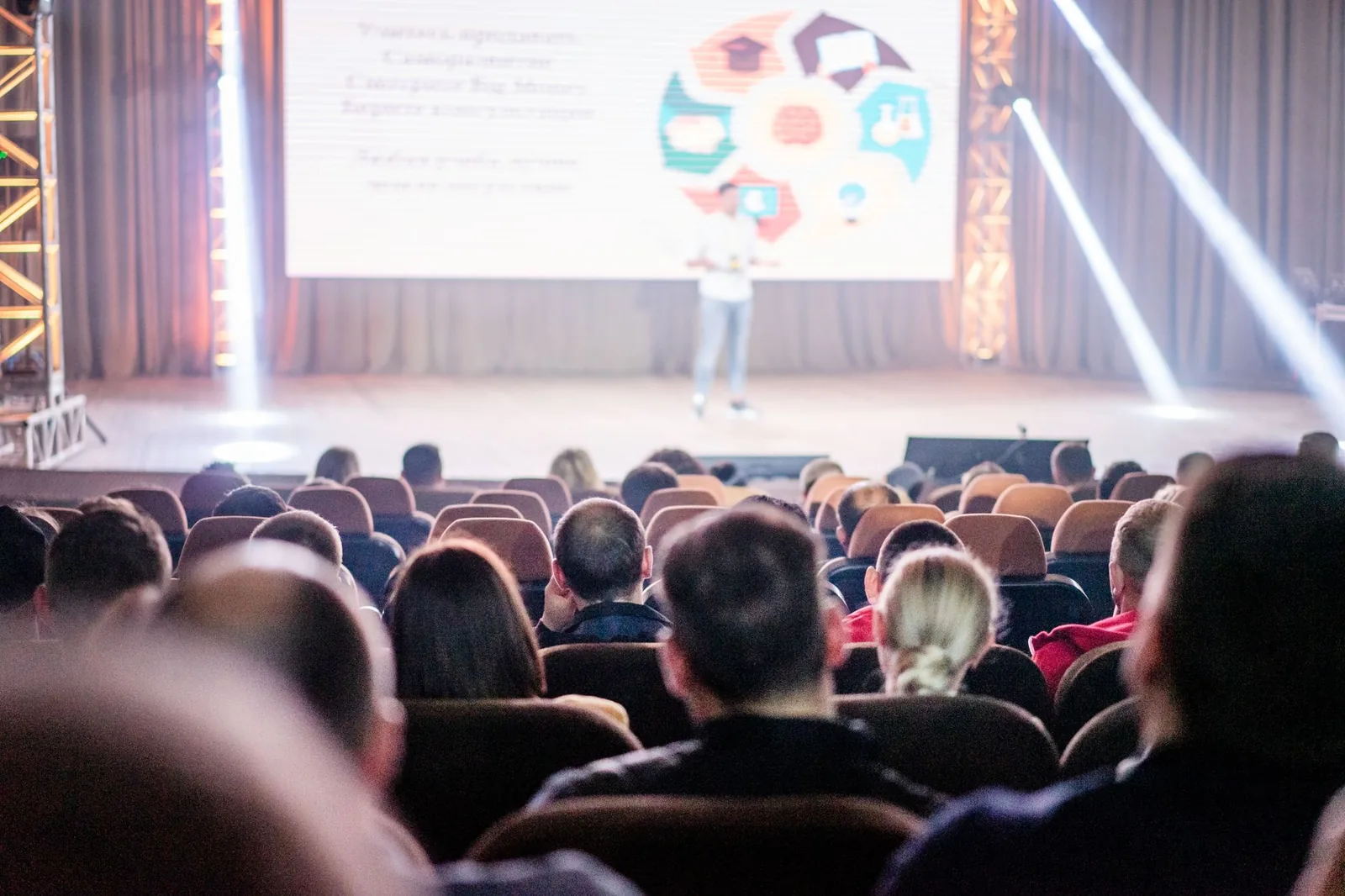 Attendees at a London tech conference watching an AI adoption panel presentation on stage