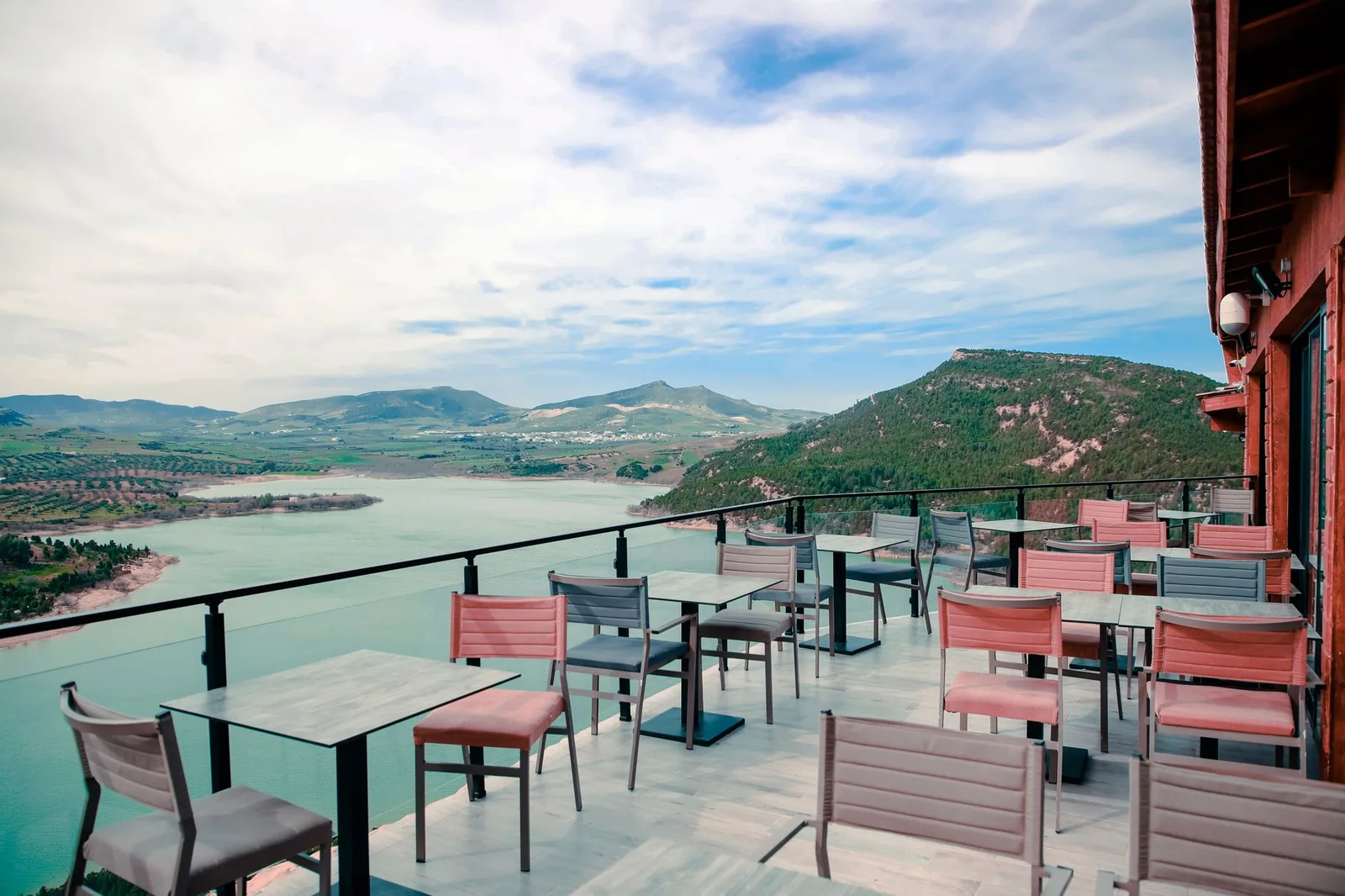 Seaside konoba terrace in Montenegro with set tables overlooking the Adriatic coast at sunset