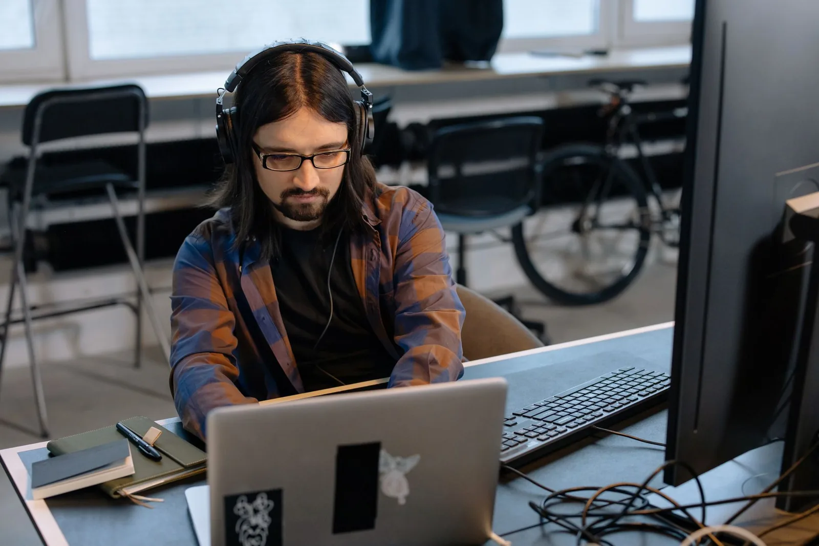 Web developer reviewing website design mockups and pricing quotes on a laptop in a Serbian office