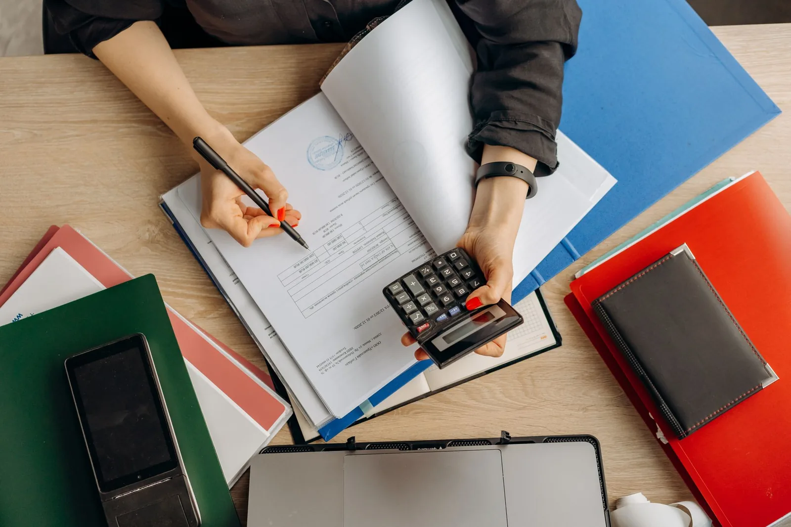 Auditor reviewing financial workpapers on laptop with spreadsheets, illustrating AI automation in audit engagements